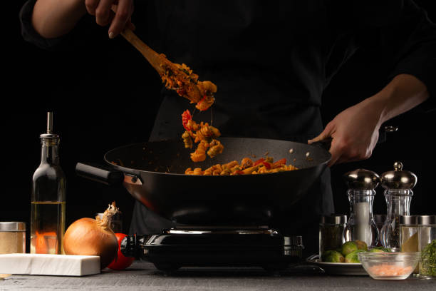 Chef sprinkling spices over a sizzling pan of food, showcasing everyday spice mastery